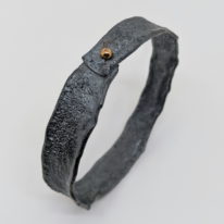 Narrow Oxidized Silver Bangle with Gold Ball by Barbara Adams at The Avenue Gallery, a contemporary fine art gallery in Victoria, BC, Canada.
