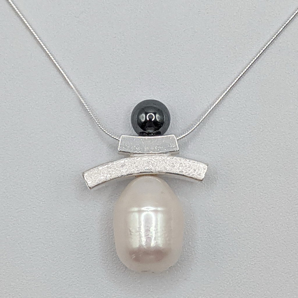Balance Inukshuk Necklace with Hematite & White Pearl by Chi's Creations at The Avenue Gallery, a contemporary fine art gallery in Victoria, BC, Canada.