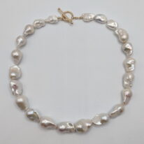 White Baroque Pearl Necklace with Yellow Gold-Plated Toggle Clasp by Val Nunns at The Avenue Gallery, a contemporary fine art gallery in Victoria, BC, Canada.